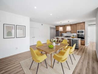 This stunning property features a modern dining area with a wooden table and stylish yellow chairs.