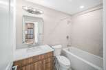 Step into this modern bathroom, featuring a sleek vanity with a bright white countertop and warm wood cabinetry.