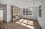 This stunning living space boasts a modern fireplace with a stone facade, creating a warm and inviting atmosphere.