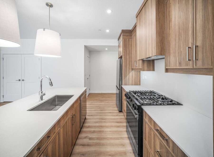 Step into this stunning kitchen, featuring sleek countertops and modern cabinetry.