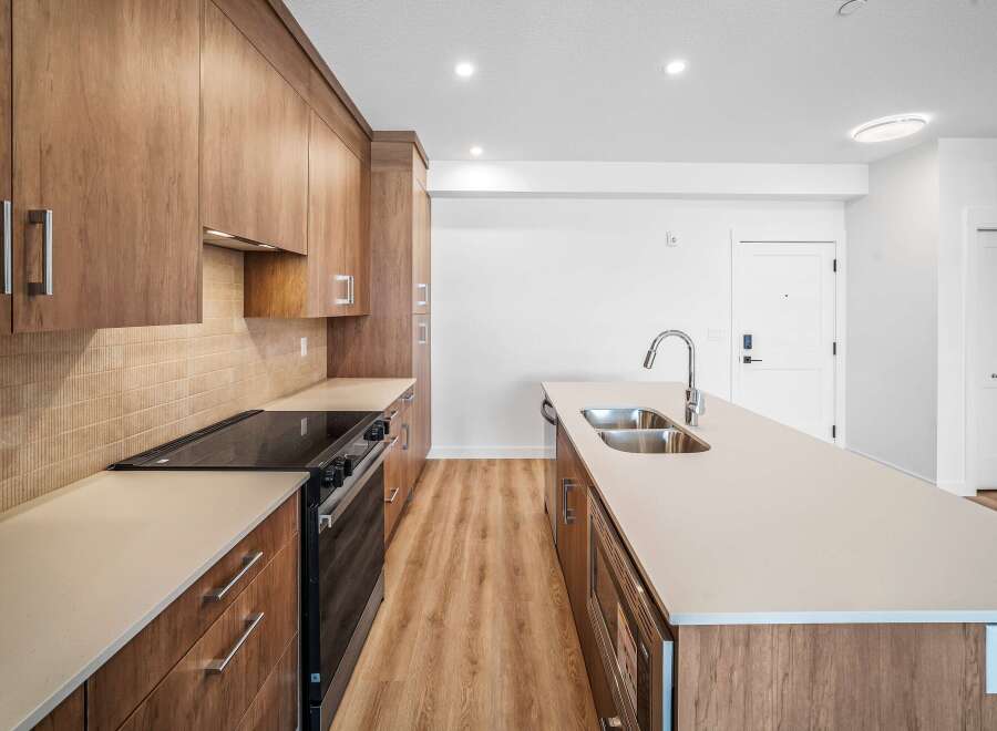 This modern kitchen boasts sleek wooden cabinetry and a spacious island, perfect for culinary enthusiasts.