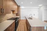 This modern kitchen boasts sleek wooden cabinetry and a spacious island, perfect for culinary enthusiasts.