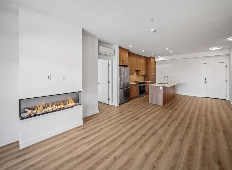 Experience modern living in this stunning property featuring a sleek fireplace and a contemporary kitchen.