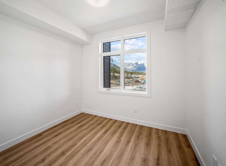 This bright and airy room features a large window offering stunning mountain views, perfect for enjoying the natural beauty.