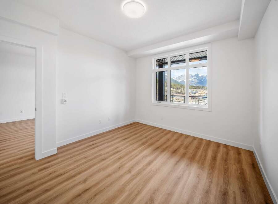 This bright and airy room features stunning mountain views through large windows, creating a serene atmosphere.