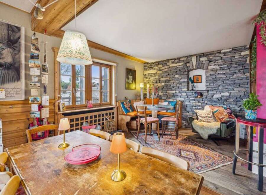 This charming property boasts a rustic interior with exposed wooden beams and a stone accent wall, creating a warm and inviting atmosphere.