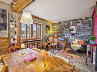 This charming property boasts a rustic interior with exposed wooden beams and a stone accent wall, creating a warm and inviting atmosphere.