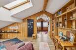 This charming property boasts a unique, rustic interior with wooden paneling and a cozy atmosphere.