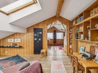 This charming property boasts a unique, rustic interior with wooden paneling and a cozy atmosphere.