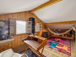 Discover the charm of this unique property, featuring a cozy reading nook and a stylish desk area.