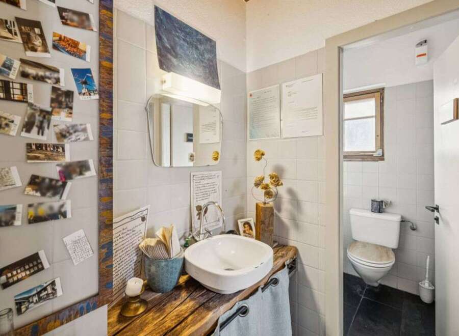 This charming bathroom boasts a unique, rustic design with a wooden countertop and a stylish sink.
