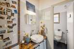 This charming bathroom boasts a unique, rustic design with a wooden countertop and a stylish sink.