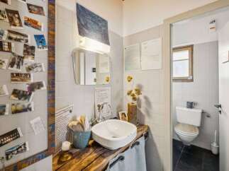 This charming bathroom boasts a unique, rustic design with a wooden countertop and a stylish sink.