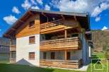 Discover this stunning property featuring a beautiful wooden facade and multiple balconies, perfect for enjoying the scenic views.