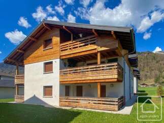 Discover this stunning property featuring a beautiful wooden facade and multiple balconies, perfect for enjoying the scenic views.
