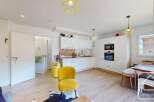 Discover this stunning property featuring a modern kitchen with sleek white cabinetry and integrated appliances.