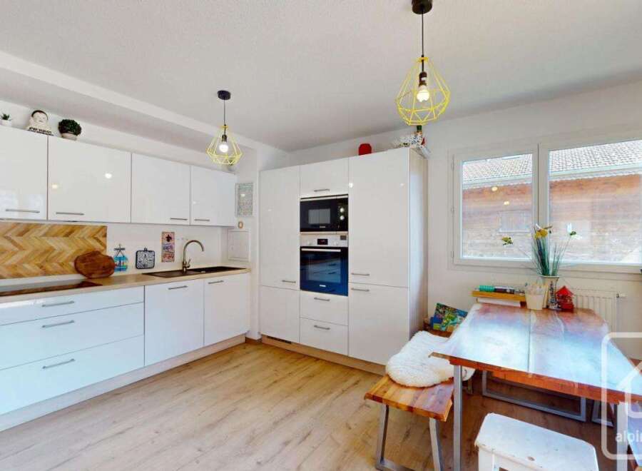 Discover this stunning modern kitchen, featuring sleek white cabinetry and a stylish wooden backsplash.