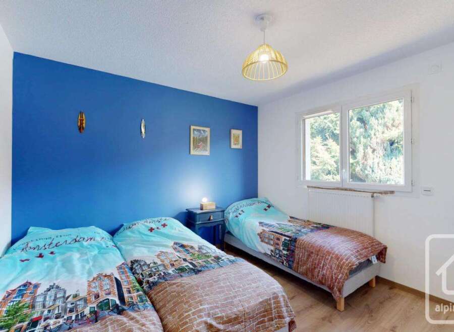 Discover this charming bedroom featuring a vibrant blue accent wall, creating a cozy and inviting atmosphere.