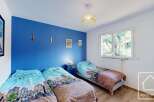 Discover this charming bedroom featuring a vibrant blue accent wall, creating a cozy and inviting atmosphere.