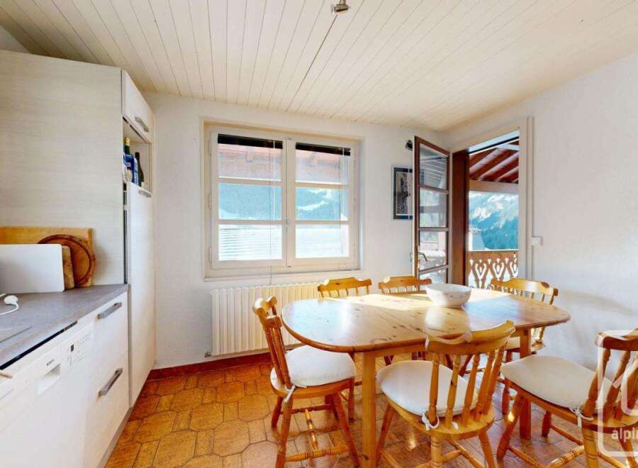 This charming kitchen features a cozy dining area with a wooden table and chairs, perfect for enjoying meals with family and friends.