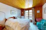 This charming bedroom features a cozy wooden ceiling and walls, creating a warm and inviting atmosphere.