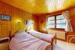 This charming bedroom features a cozy ambiance with its wooden paneling and warm lighting.