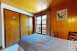 This charming bedroom features a cozy wooden ceiling and walls, creating a warm and inviting atmosphere.