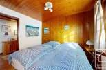 This cozy bedroom features a warm wooden ceiling and walls, creating a rustic and inviting atmosphere.