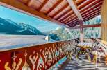 Enjoy breathtaking mountain views from this charming chalet balcony.