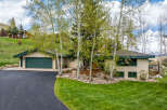 This stunning property boasts a beautiful exterior with a lush green lawn and mature trees.