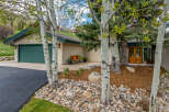This stunning property boasts a beautiful exterior with mature trees and lush landscaping, creating a serene and inviting atmosphere.