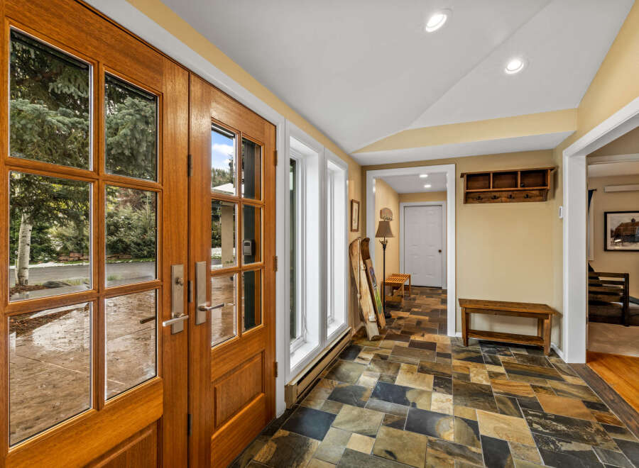 Step into this inviting entryway, showcasing a stunning wooden double door that welcomes you.