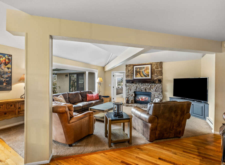 Step into luxury with this stunning living room, featuring a cozy fireplace and a large flat-screen TV, perfect for entertaining.