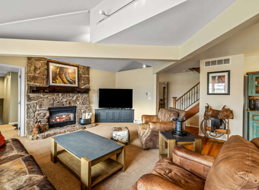 This stunning living room boasts a cozy stone fireplace, perfect for chilly evenings.