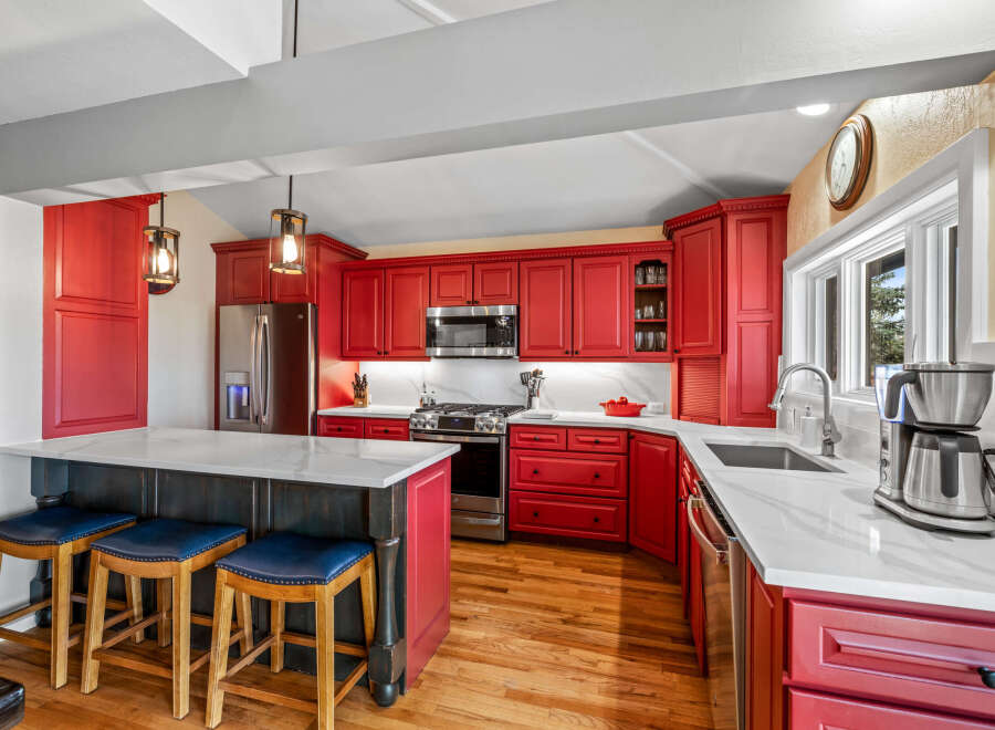 This stunning kitchen boasts a vibrant red cabinetry, creating a bold and inviting atmosphere.