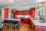 This stunning kitchen boasts a vibrant red cabinetry, creating a bold and inviting atmosphere.