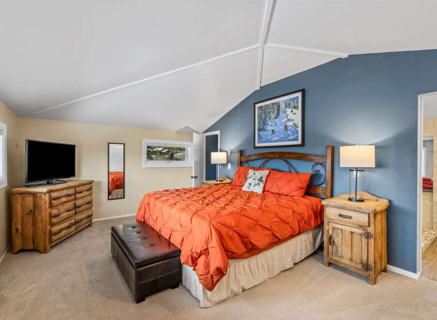 This cozy bedroom features a rustic wooden dresser and nightstands, adding a touch of warmth and charm.