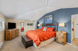 This cozy bedroom features a rustic wooden dresser and nightstands, adding a touch of warmth and charm.