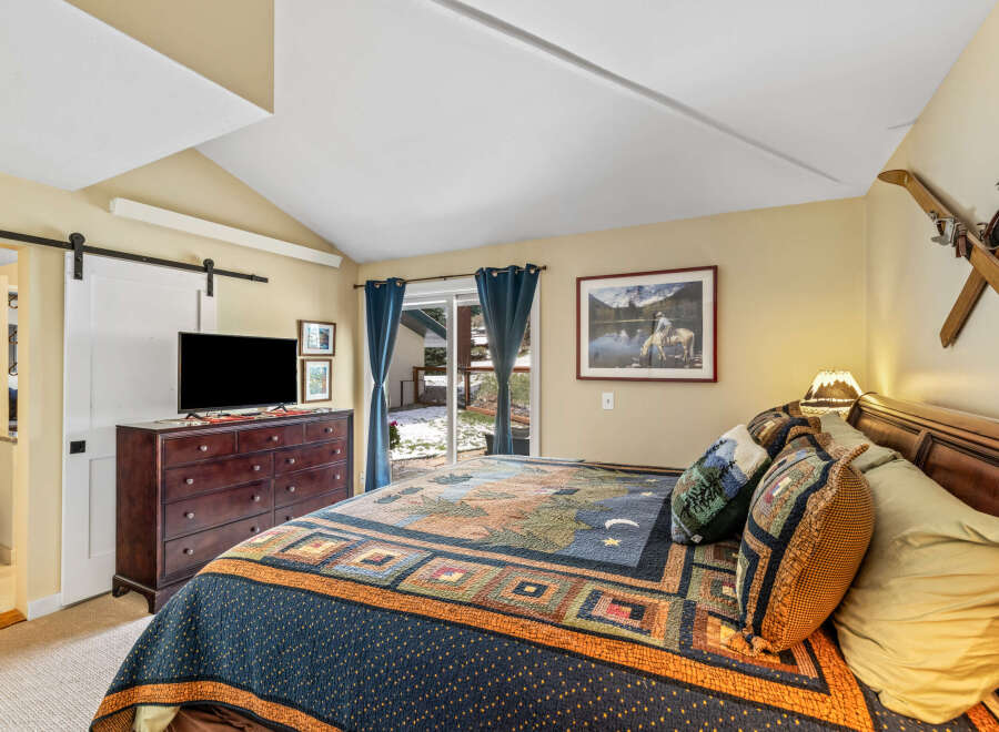 This cozy bedroom features a rustic design with a comfortable bed and a beautiful quilt.