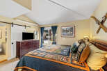 This cozy bedroom features a rustic design with a comfortable bed and a beautiful quilt.