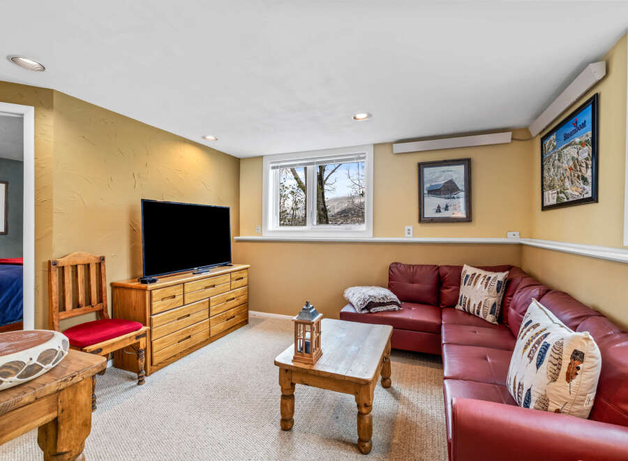 This cozy living space features a comfortable red leather sectional sofa, perfect for relaxing.