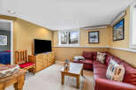 This cozy living space features a comfortable red leather sectional sofa, perfect for relaxing.