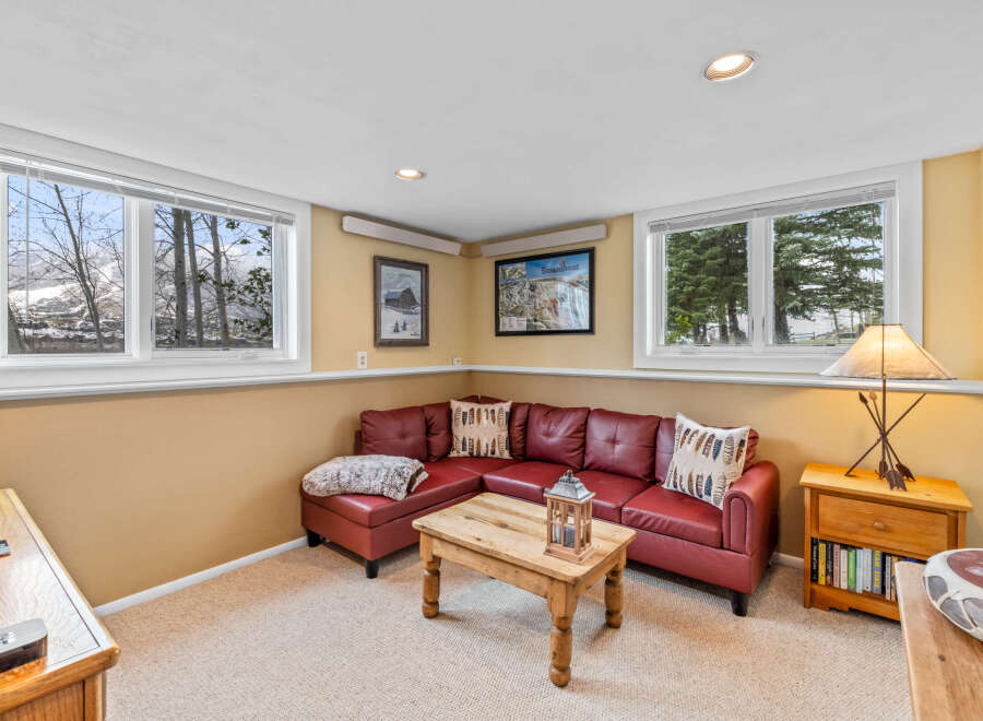 This cozy living room features a comfortable red leather sectional sofa, perfect for relaxing.