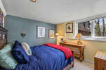 This cozy bedroom features a comfortable bed with a vibrant blue comforter and a warm red throw blanket.