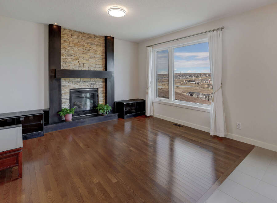 This stunning living room boasts a beautiful stone fireplace, creating a warm and inviting atmosphere.