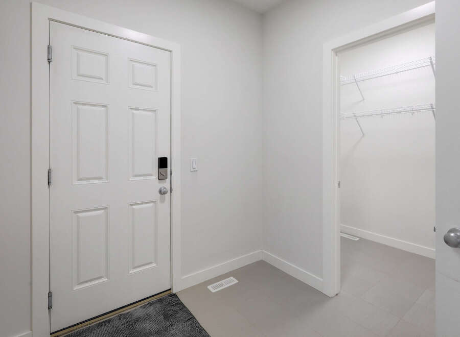 Step into this inviting entryway, featuring a modern white door and a convenient closet.