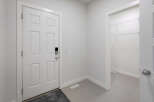 Step into this inviting entryway, featuring a modern white door and a convenient closet.