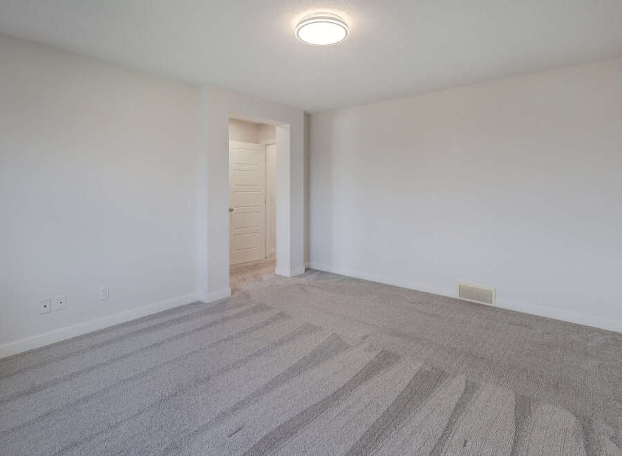 Step into this bright and airy room, featuring pristine white walls and plush, neutral-toned carpeting.