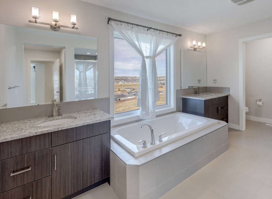 This luxurious bathroom features a modern design with a large soaking tub and a stunning view.