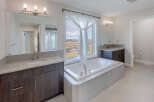 This luxurious bathroom features a modern design with a large soaking tub and a stunning view.